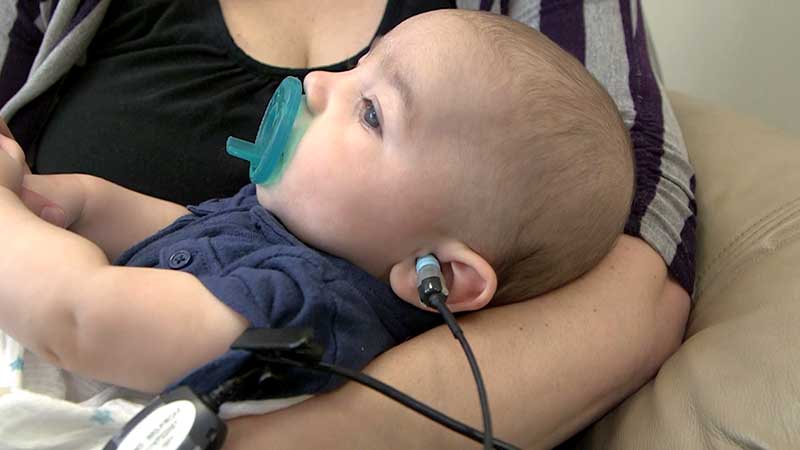 Baby held by mother during OAE test