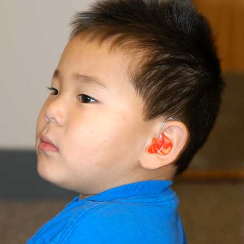 boy with colorful pediatric hearing aid