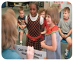 Girls looking at teacher holding book