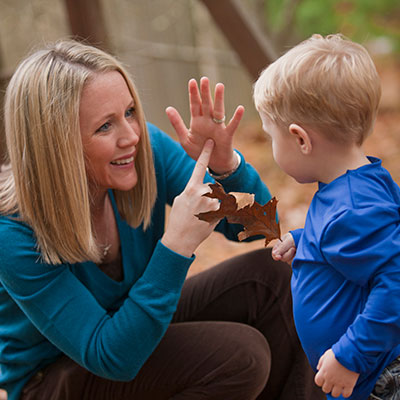 Adult looking at child and using sign language